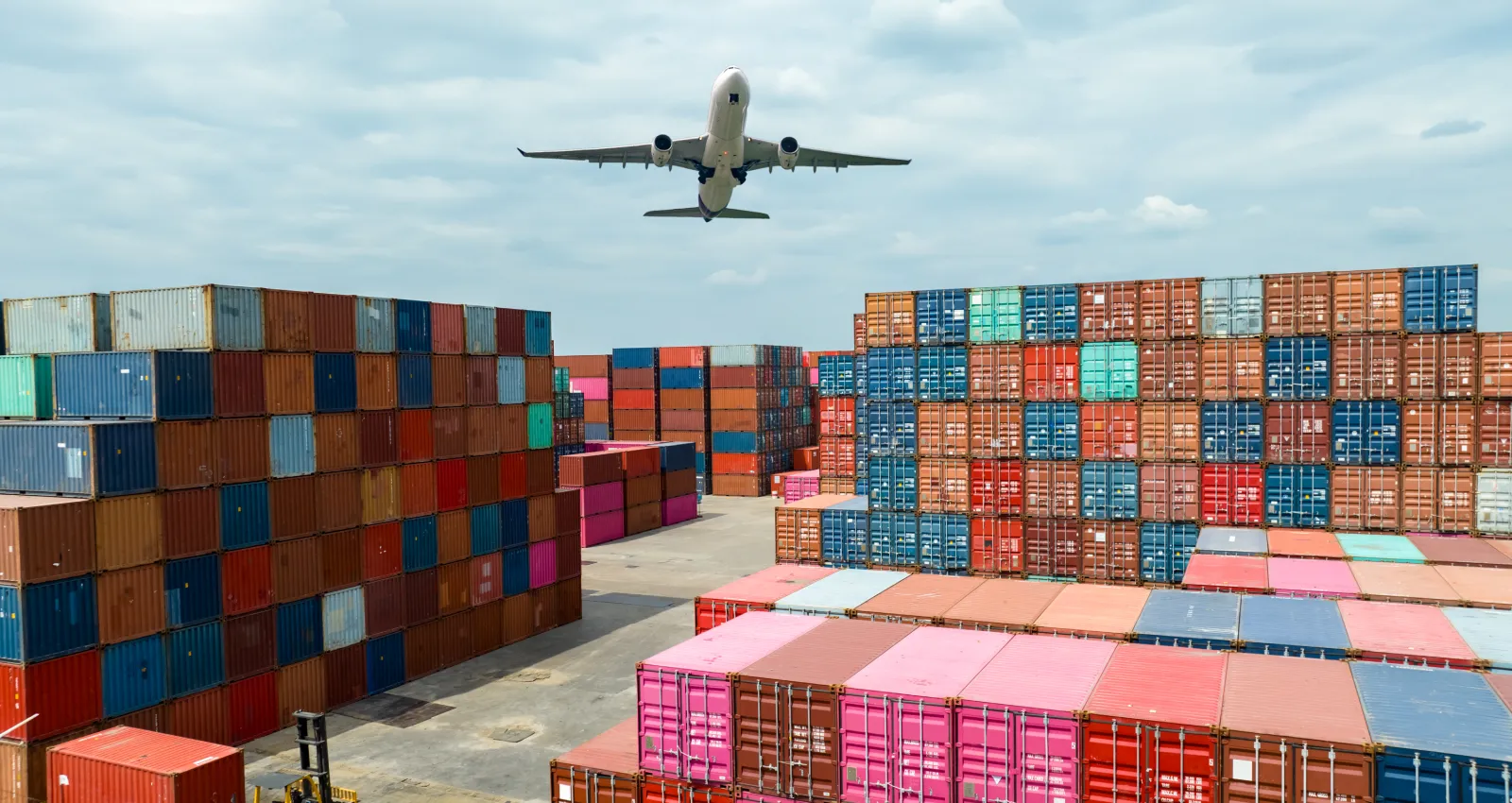 Airplane over shipping containers